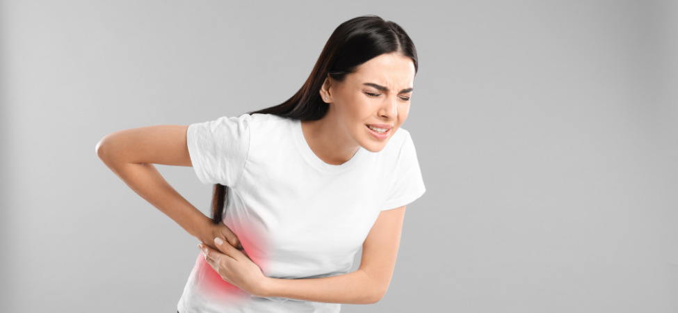 Mulher branca de cabelo preto com dor na região dos rins